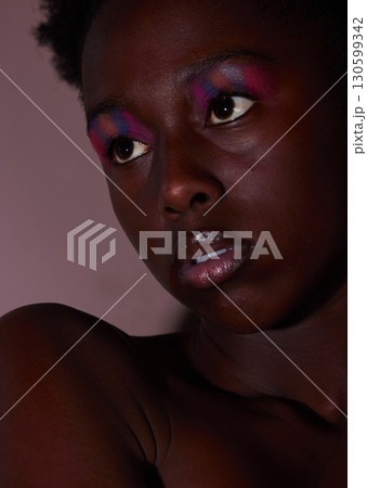 Face, thinking and makeup with a model black woman in studio on a mauve background for beauty. Skincare, idea and cosmetics with an attractive young female posing indoor to promote natural care 130599342