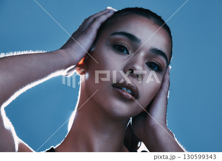Beauty skincare, face portrait and woman in studio isolated on a blue background. Makeup light, cosmetics and aesthetics of female model satisfied after facial treatment for healthy and glowing skin. 130599343