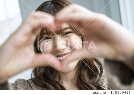 手でハートを作る若い女性 130599451