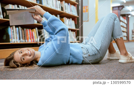 Portrait, woman on floor and reading in library, relax and learning with smile, hobby or higher education. Female student girl or lady with book, knowledge or college research for studying and campus Portrait, woman on floor and reading in library, relax and learning with smile, hobby or higher education. Female student girl or lady with book, knowledge or college research for studying and campus 130599570