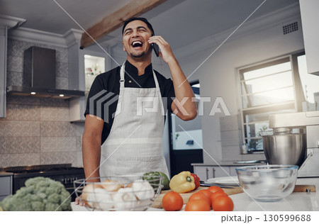 Man, phone call and laughing or cooking in kitchen for healthy nutrition, food diet and organic vegetables salad. Young male, chef happiness and smile for smartphone call or cook dinner in home 130599688