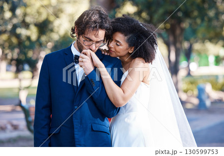 Wedding, couple and kiss while holding hands outdoor at marriage celebration event together with commitment. Interracial man and woman with trust, partnership and respect or care in nature park 130599753