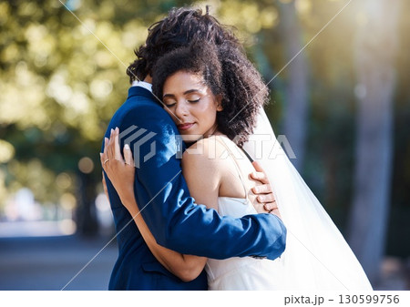 Care, hug and wedding bride with groom at romantic outdoor marriage event celebration together. Partnership, commitment and trust embrace of married interracial couple in nature with bokeh. 130599756