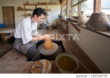 ろくろを使って器を形作る若い男性 ろくろを使って器を形作る若い男性 130599776