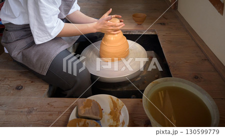 ろくろを使って器を形作る男性の手元 130599779