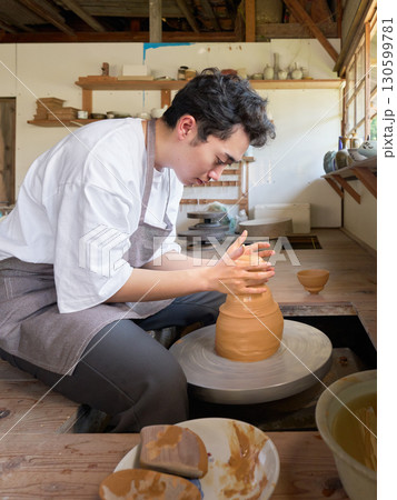 ろくろを使って器を形作る若い男性 130599781
