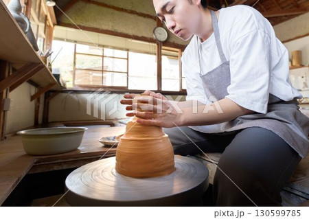 ろくろを使って器を形作る若い男性 130599785