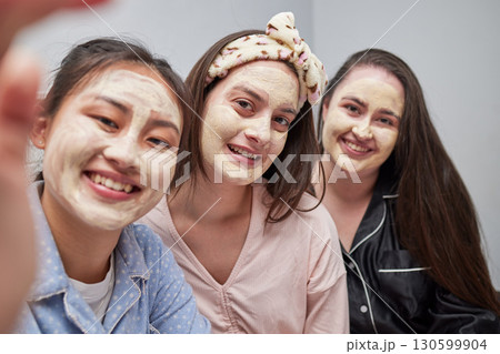 Friends, women and sleepover with mask, selfie and bonding with cosmetics, smile and quality time. Females, girls and photo for posting, dermatology or skincare with ladies, treatment or fun together 130599904