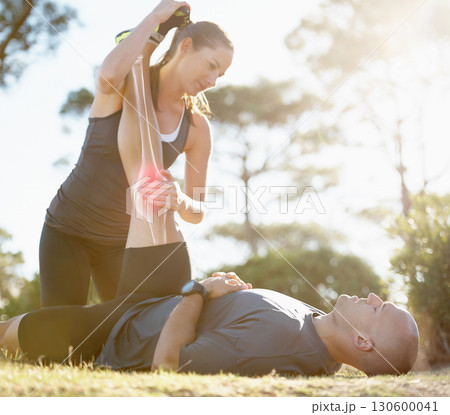 Fitness, couple and helping or stretching leg for healthcare, pain or ache after running workout in nature. Happy woman holding man legs for stretch to sooth painful knee or area from cardio exercise 130600041