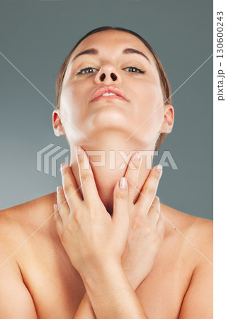 Woman, beauty and skincare holding neck in satisfaction for cosmetic treatment against grey studio background. Portrait of beautiful female touching soft, smooth or perfect skin for healthy wellness 130600243