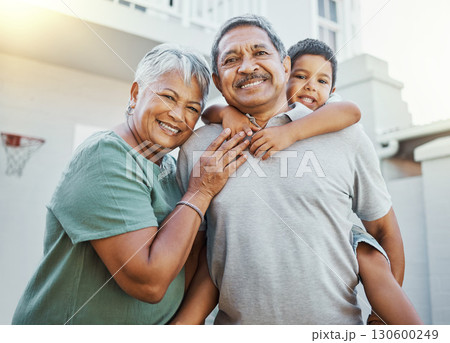 Piggyback, love and portrait of grandparents with a child in the backyard of their family home. Happiness, smile and elderly man and woman in retirement bonding with grandson outdoor their house. 130600249