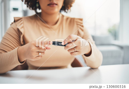 Diabetes, finger of black woman and blood test in hands, healthcare and medicine in home. Health, innovation and technology, diabetic person with digital glucometer checking glucose or sugar level. 130600316