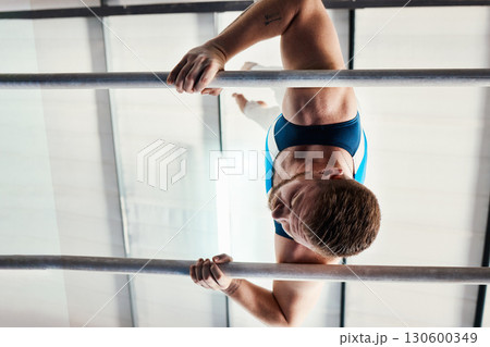 Gymnastics man, bars and exercise with balance, strong body and focus for sports, vision and professional career. Gymnast, athlete and training with muscle development, workout and low angle at gym 130600349