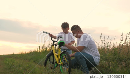 happy smile boy child, happy family outdoors, fun game nature, child kid little son man fix broken bicycle, adrenaline fast cycling, child learns ride bicycle, childhood grass, father running after 130600514
