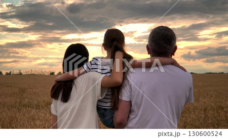happy family, parents kid girl watching sunset, child mother father hugging sunset nature, Family moments during sundown, Back view of loving family, Generations united at dusk, Family silhouette in 130600524