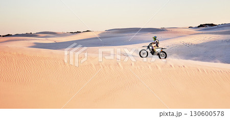 Desert, nature and athlete riding a motorcycle for exercise, fitness or skill training in nature. Extreme sports, action and male athlete on a bike for an outdoor workout in the sand dunes in Dubai. Desert, nature and athlete riding a motorcycle for exercise, fitness or skill training in nature. Extreme sports, action and male athlete on a bike for an outdoor workout in the sand dunes in Dubai. 130600578