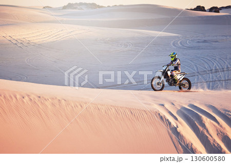 Desert, moto cross and extreme motorbike sport of a man on sand dunes in Africa doing fitness. Driving challenge, beach adventure and cycling travel of a athlete in nature training for moto cross Desert, moto cross and extreme motorbike sport of a man on sand dunes in Africa doing fitness. Driving challenge, beach adventure and cycling travel of a athlete in nature training for moto cross 130600580