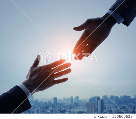 都市を背景に手を差し伸べるビジネスパーソンのグループ バナー・広告向けビジュアル 都市を背景に手を差し伸べるビジネスパーソンのグループ バナー・広告向けビジュアル 130600628