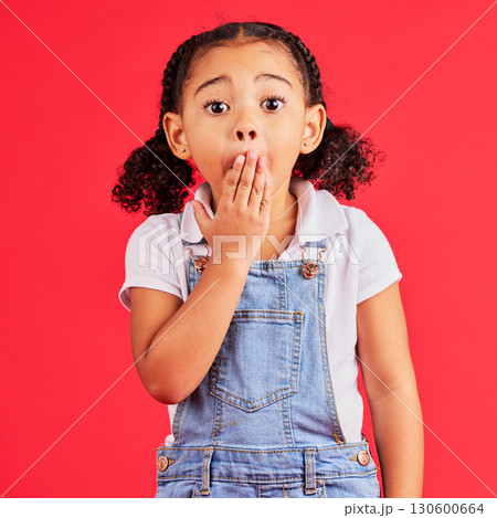 Shocked kid, portrait and hand on mouth in secret, oops and mistake facial expression on isolated red background. Child, little girl and surprised face in gossip, news or emoji at studio announcement 130600664