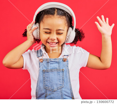 Dancing, child and headphones for music, fun radio and girls podcast on isolated red background and studio. Smile, happy and energy kid listening to dance audio, sound and streaming media on backdrop 130600772