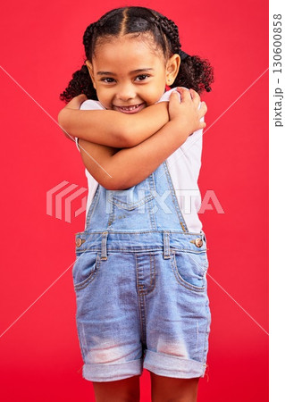 Portrait, hug and girl in studio, happy and smile against red background with mockup. Face, love and caring toddler standing against space, embrace and positive, smiling and self love while isolated 130600858