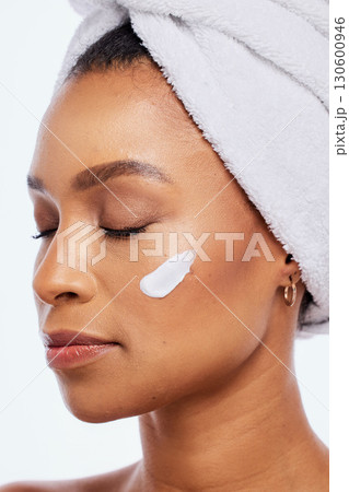 Black woman, skin care and beauty cream in studio for dermatology, cosmetics and natural glow. Aesthetic model person with luxury spa facial and healthy face with towel isolated on a white background 130600946