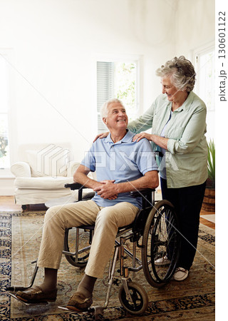 Disability, wheelchair and happy senior couple enjoy affection and bonding together. Retirement home, marriage and elderly woman and man smile in living room for relax, support and love with mockup 130601122