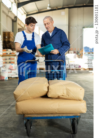 Elderly man and young guy check documents in warehouse Elderly man and young guy check documents in warehouse 130601181