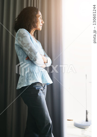Window, depression and senior woman with stress, burnout and isolated in home, anxiety or arms crossed. Mature female, mental health or lady with doubt, anxious or thinking with bad news or depressed Window, depression and senior woman with stress, burnout and isolated in home, anxiety or arms crossed. Mature female, mental health or lady with doubt, anxious or thinking with bad news or depressed 130601244