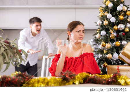 Annoyed young male and female getting mad at each other while standing near of Christmas tree in apartment 130601461