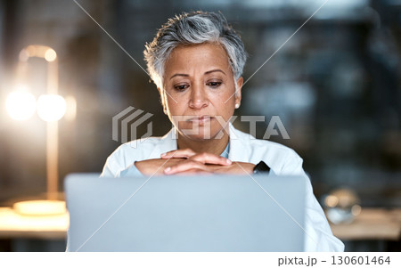 Senior woman, doctor and laptop at night thinking for healthcare solution, idea or strategy at hospital. Elderly female medical expert working late on computer and contemplating decision or choice 130601464