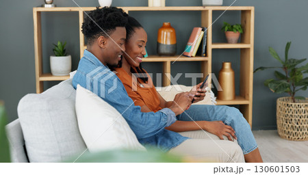 Internet, technology and couple with phone on sofa in living room. Black man, young woman and a banking app, online shopping or social media on a mobile on a couch at home for communication and relax 130601503
