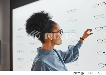 Vision, optometry and black woman shopping for glasses, spectacles or frames at optical store. Eye care, ophthalmology and happy female customer with choice or decision for retail lenses or eyewear. 130601566