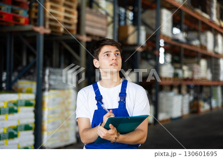Young guy warehouse worker checking documents 130601695