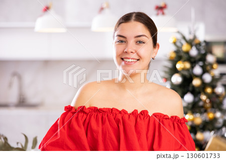 in atmosphere of new year, girl charmingly smiles, looking into camera of photographer in atmosphere of new year, girl charmingly smiles, looking into camera of photographer 130601733