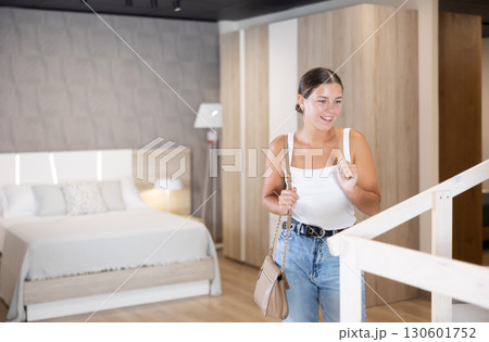 Young girl choosing convenient mattress in furniture shop 130601752