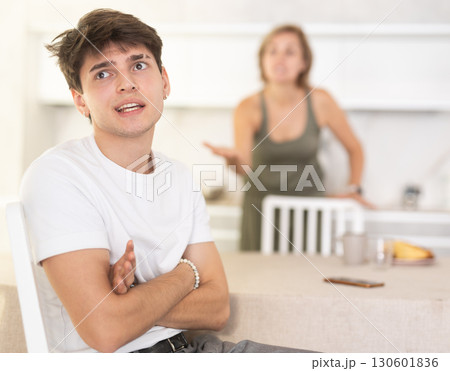 Angry woman swears at young guy, family quarrel. Angry woman swears at young guy, family quarrel. 130601836