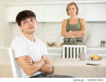 Adult woman quarreling with young guy in kitchen Adult woman quarreling with young guy in kitchen 130601882