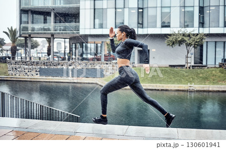 Run, rain and black woman with fitness, workout and training for marathon, wellness and healthy lifestyle. Wet, African American female athlete and runner outdoor, practice and balance for energy 130601941