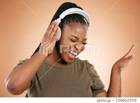Headphones, singing and black woman isolated on studio background for mental health, energy and radio music. Singer, voice and gen z african person listening to audio technology with mockup space Headphones, singing and black woman isolated on studio background for mental health, energy and radio music. Singer, voice and gen z african person listening to audio technology with mockup space 130602359