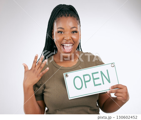 Black woman, excited and holding open sign for announcement or message against a grey studio background. Portrait of African American female manager advertising startup opening or ready for service 130602452