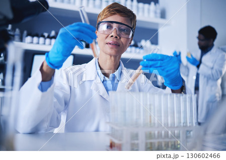 Glass vials, scientist and mature woman doing research, experiment or tests in a medical lab. Innovation, professional and senior female scientific researcher working in a pharmaceutical laboratory. 130602466