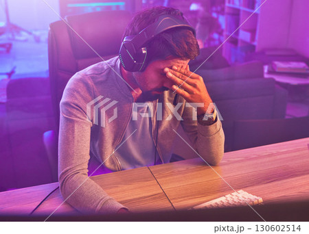 Stress, gamer or man with headache from loss, fail or online competition tournament anxiety in room. Neon, sad or depression male for gaming mental health, live stream disappointment or esport glitch 130602514