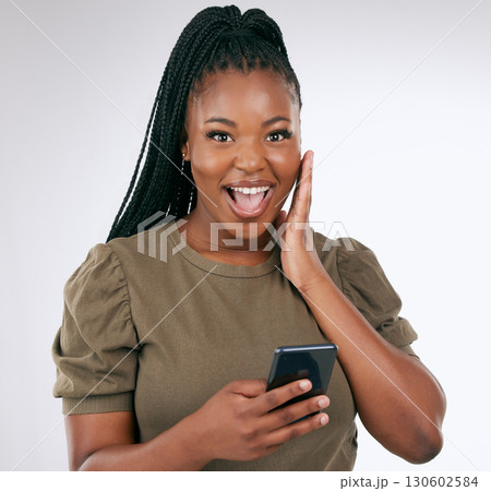 Black woman, surprise face in portrait with smartphone, wow facial expression isolated on gradient background. Happy in studio, notification on social media or email, alert or announcement with shock Black woman, surprise face in portrait with smartphone, wow facial expression isolated on gradient background. Happy in studio, notification on social media or email, alert or announcement with shock 130602584
