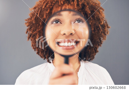 Funny, smile and black woman with a magnifying glass on face isolated on a grey studio background. Happy, comic and facial zoom of a girl with a magnifier for comedy, happiness and discovery Funny, smile and black woman with a magnifying glass on face isolated on a grey studio background. Happy, comic and facial zoom of a girl with a magnifier for comedy, happiness and discovery 130602668