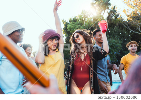 Pool party, drinks and group of friends outdoor to celebrate at festival, location or summer social event. Diversity young men and women people together while dancing, happy and drinking alcohol Pool party, drinks and group of friends outdoor to celebrate at festival, location or summer social event. Diversity young men and women people together while dancing, happy and drinking alcohol 130602680