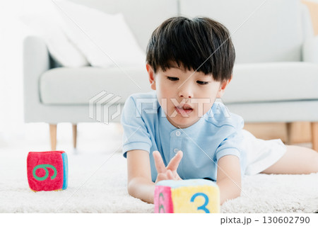 数字サイコロで遊ぶ男の子 130602790