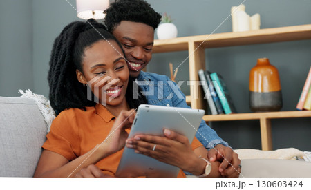 Love, sofa and black couple and tablet watching a video and relax together in the living room. African people, smile and happy from series streaming and funny meme on social media and app on couch 130603424