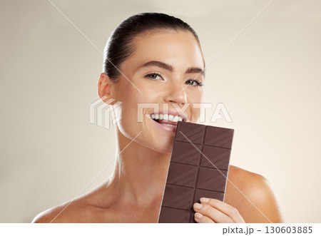 Beauty portrait, eating and woman with chocolate bar, junk food or dessert for sugar sweets, candy snack or cheat meal. Cosmetics makeup, skincare and hungry model with cacao product for antioxidants Beauty portrait, eating and woman with chocolate bar, junk food or dessert for sugar sweets, candy snack or cheat meal. Cosmetics makeup, skincare and hungry model with cacao product for antioxidants 130603885