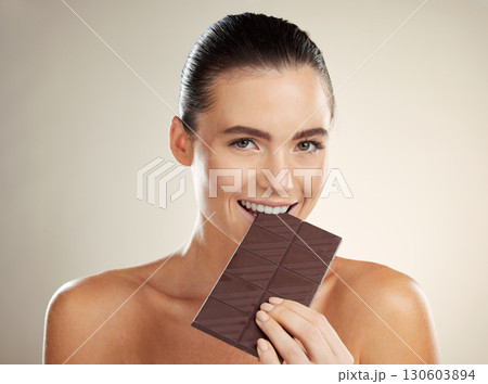 Beauty portrait, eating and woman with chocolate, junk food or dessert for sugar sweets, candy snack or cheat meal. Cosmetics makeup, skincare and hungry model with cacao product for antioxidants Beauty portrait, eating and woman with chocolate, junk food or dessert for sugar sweets, candy snack or cheat meal. Cosmetics makeup, skincare and hungry model with cacao product for antioxidants 130603894